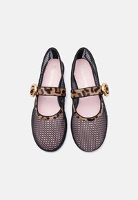 Ballerines Mary Jane en mesh noir avec des brides à imprimé léopard et des boucles circulaires dorées, semelles intérieures roses, vues de dessus sur fond blanc.