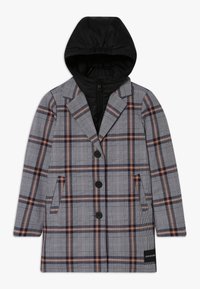 Abrigo largo de cuadros con rayas en negro, blanco y óxido, que presenta una capa interior con capucha de cremallera negra y tres botones frontales negros.