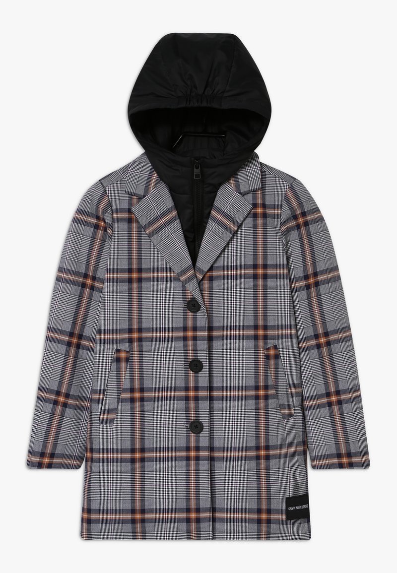 Abrigo largo de cuadros con rayas en negro, blanco y óxido, que presenta una capa interior con capucha de cremallera negra y tres botones frontales negros.