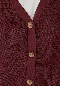 Cárdigan de punto burdeos con escote en V, que presenta un patrón texturizado y cinco botones de madera en la parte delantera.