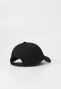 Boné de basebol preto feito de algodão, com uma aba curva e uma correia ajustável na parte de trás com uma fivela metálica. Textura suave.