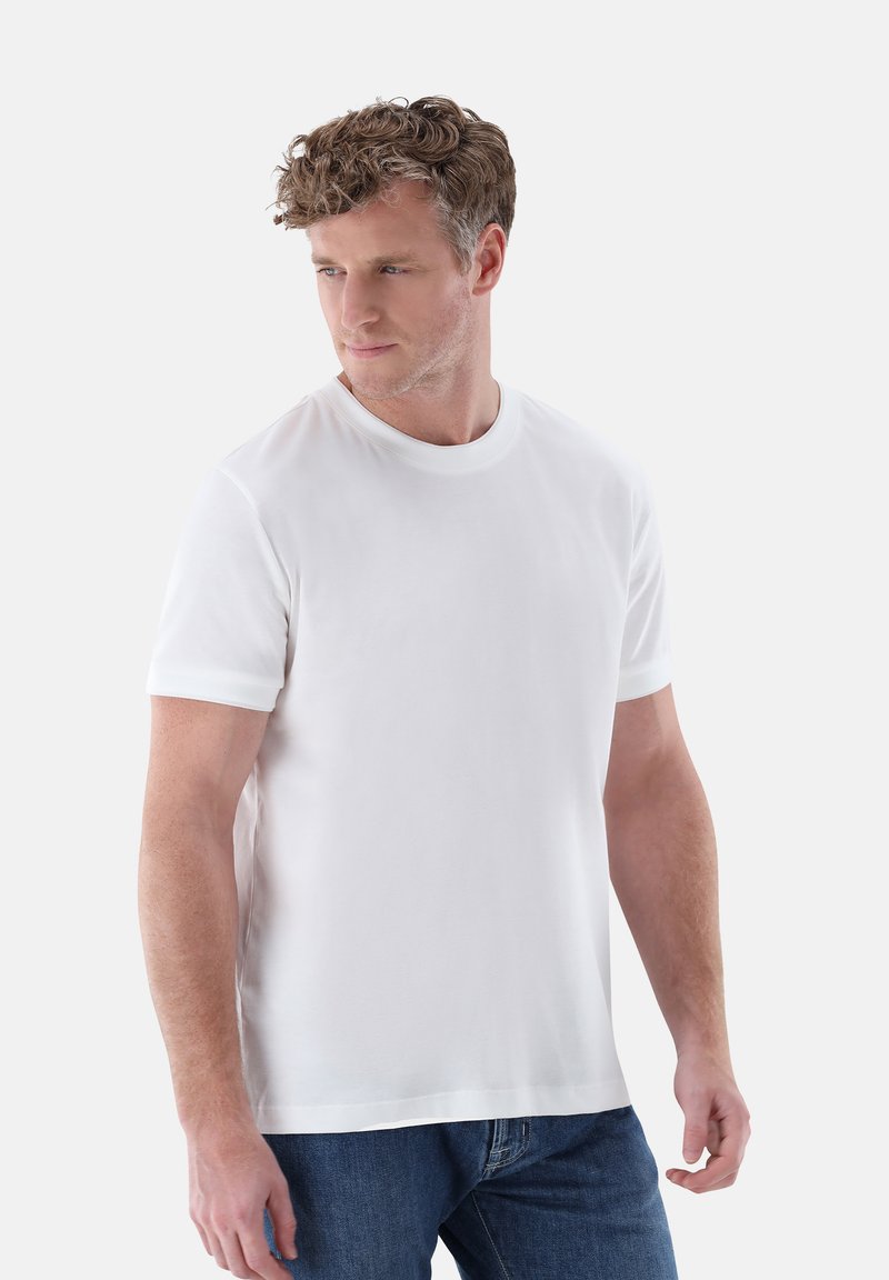 Weißes Baumwoll-T-Shirt mit kurzen Ärmeln, Rundhalsausschnitt und glatter Textur, kombiniert mit blauen Jeans. Einfaches, klassisches Design.