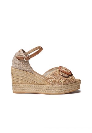 Puntige sandaal met geweven natuurlijke vezels in beige, met bloemrijke borduurwerk en een verstelbare bruine enkelriem. Zool van jute in espadrille-stijl.