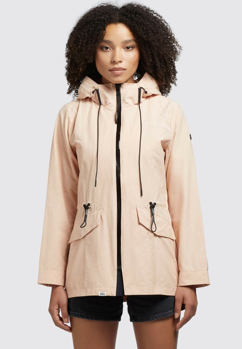Light pink waterproof jacket with a hood, adjustable drawstrings, front zip closure, and two front pockets. Features a textured fabric.