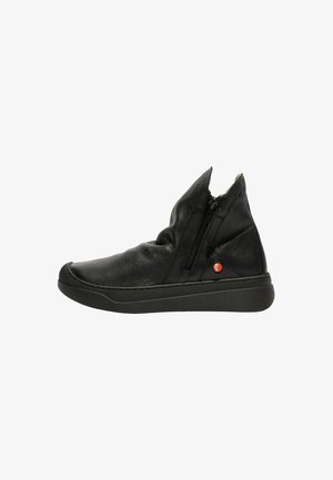 Stivaletti alla caviglia in pelle nera con una texture liscia, dotati di una zip angolare lungo il lato e di una suola in gomma minimalista con un accento circolare.