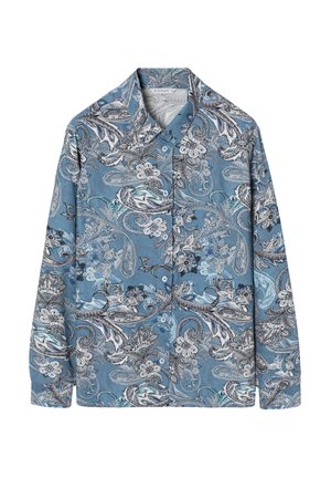 Chemise à manches longues en tissu bleu clair avec des motifs complexes paisley et floraux en noir et blanc. Elle présente un col pointu et une patte de boutonnage devant.