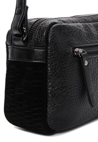 Bolso bandolera de cuero negro con parte superior texturizada, sección inferior lisa, cierre de cremallera y acentos de hardware elegante. Forma compacta y rectangular.