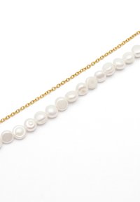 Collar de cadena de oro con perlas blancas de forma irregular, que exhibe una mezcla de texturas suaves y brillantes. El diseño presenta un espaciado simétrico.
