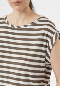 Pasiasta bluzka z krótkim rękawem w brązowo-białym kolorze, wykonana z bawełny, z szerokim dekoltem i luźnym krojem, z widocznymi szwami wzdłuż szwów.