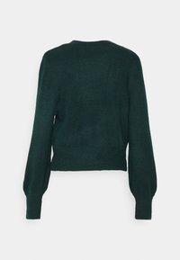 Maglione verde lavorato a maglia con collo rotondo, maniche lunghe a palloncino e orlo a costine. La texture è morbida, con una vestibilità leggermente rilassata e cropped.