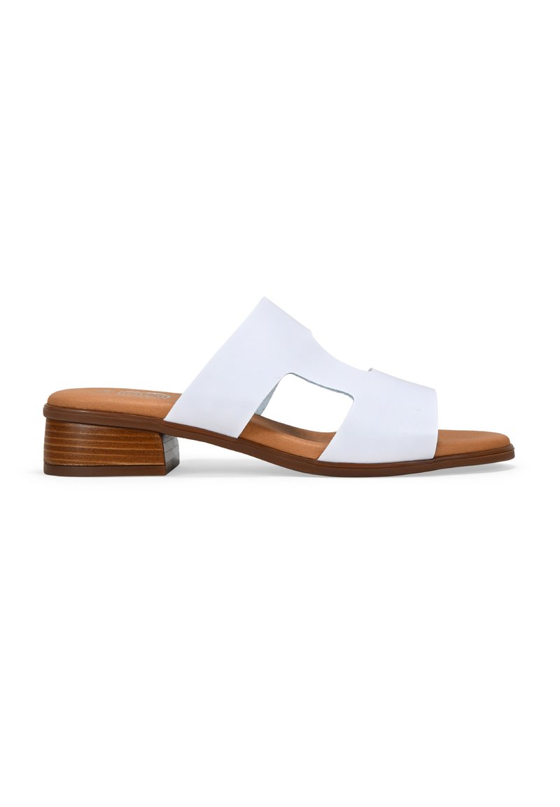 Sandalia deslizante de cuero sintético blanco con punta abierta y diseño cruzado. Tacón bajo de madera y plantilla color marrón. Superficie suave con acentos mínimos.