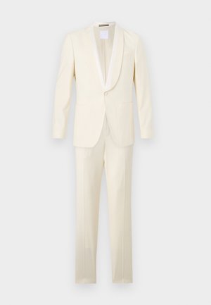 Světle krémový oblek s blazerem na jedno knoflíkové zapínání a dvěma kapsami, s saténovým šálovým límcem. Slim-fit kalhoty s hladkým povrchem.