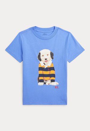 Camisa de color azul claro con una ilustración de un perro vestido con un polo a rayas negras y amarillas. Logo rojo "RL" en la esquina inferior derecha. Tela de algodón suave.