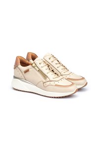 Zapatillas de cuero beige con acentos marrones, superficie texturizada, cierre de cordones y cremallera, detalle en metal dorado y suela de goma blanca.