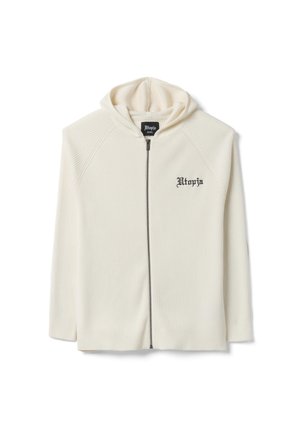 Hoodie zippé beige crème à côtes avec texte noir "Utopia" sur le côté gauche de la poitrine et capuche attachée, taille petite.