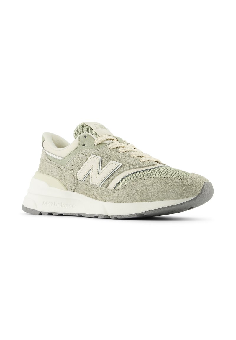 Sneaker New Balance verde chiaro e beige con tomaia in suede e rete, lacci crema e suola bianca ammortizzata.