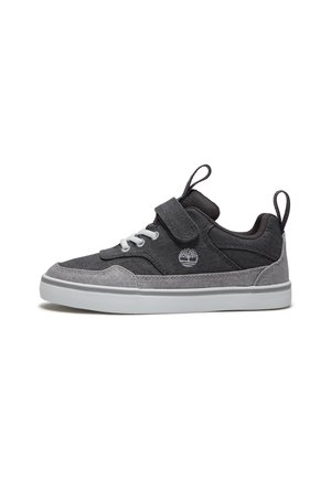 Sneaker basse nere e grigie con lacci bianchi, cinturino in velcro, anelli in tessuto sulla linguetta e sul tallone, e suola in gomma bianca.