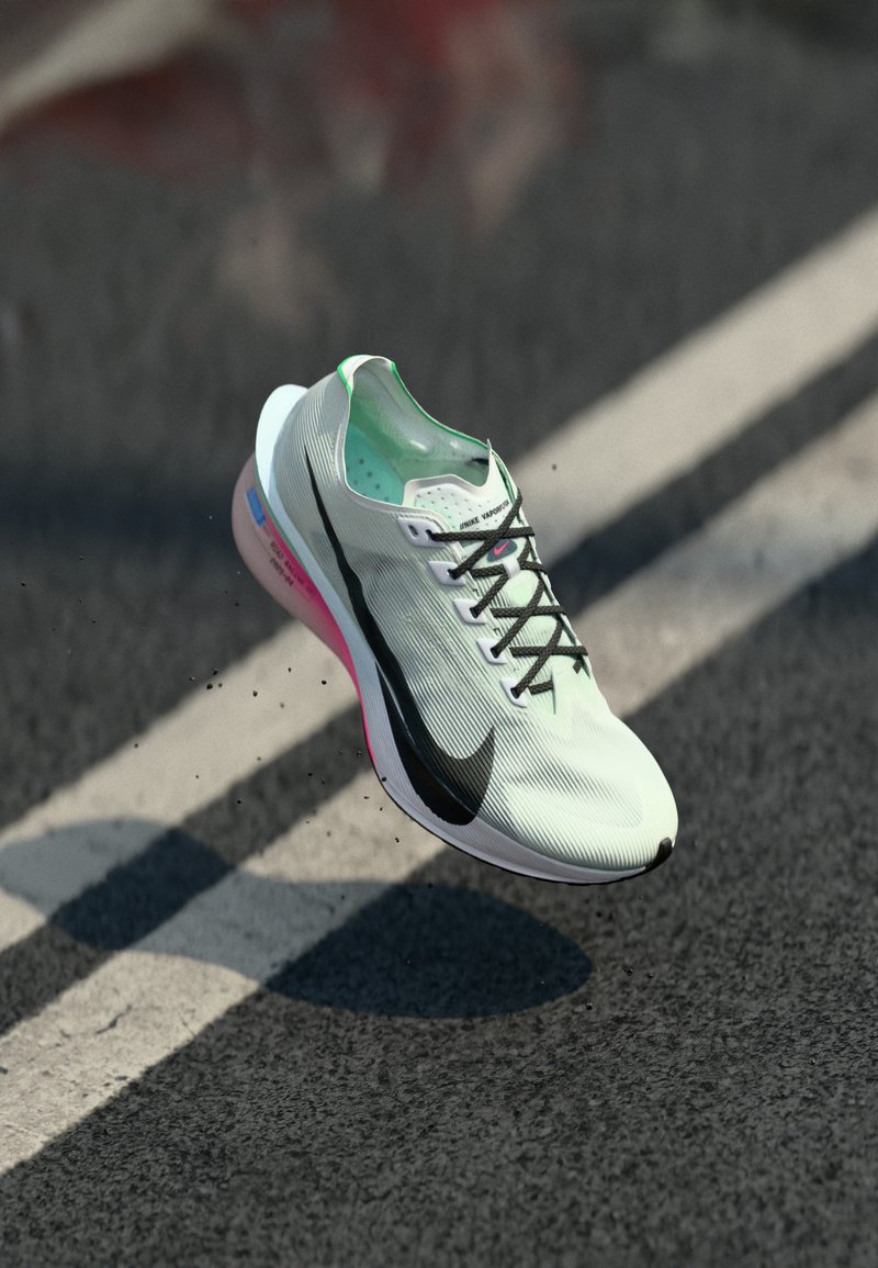 Chaussure de running légère en vert et blanc, avec un dessus texturé, un logo swoosh noir et une semelle accentuée de rose ; lacets inclus.