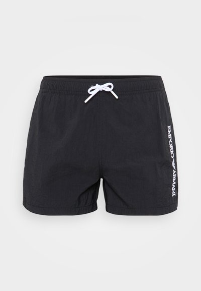 Sorte svømmeshorts laget av lett materiale, med strukturert overflate, hvit snøring og "Emporio Armani"-logo trykt på siden.