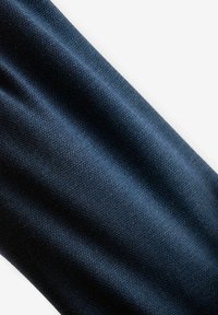 Granatowy materiał o teksturowanym splocie, ukazujący subtelne wariacje w kolorze i świetle, z gładkimi, swobodnie opadającymi fałdami.