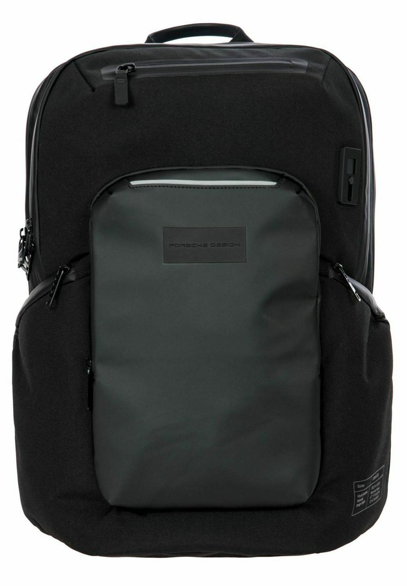 Mochila negra con una textura suave y mate y acentos brillantes. Presenta múltiples bolsillos, cremalleras y un logotipo prominente en la parte frontal.