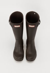 Botas de lluvia de goma marrones hasta la rodilla con un acabado mate, aberturas circulares en la parte superior y acentos del logo "HUNTER" en rojo y blanco.