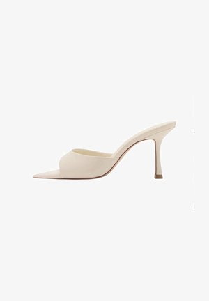 Beige high-heeled mules with an open toe, made from smooth material, featuring a curved design and a thin stiletto heel.