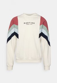 Felpa crema con maniche a chevron multicolori in rosso, verde, blu e blu navy. Presenta testo del logo nero, polsini e orlo a costine.