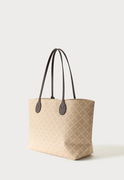 Sac fourre-tout beige avec un motif croisé subtil et de longues poignées en cuir marron foncé sur fond blanc.