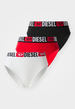 Tre par med Diesel dametruser i rød, svart og hvit. Hver av dem har en logo-bredde med svart tekst på hvit bakgrunn.