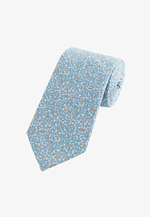 Cravate bleu clair ornée d'un motif floral avec des feuilles vertes et de petites touches d'orange. La cravate est enroulée, mettant en valeur sa forme étroite et la texture du tissu.