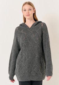 Felpa con cappuccio grigio in maglia, caratterizzata da un motivo a onda testurizzato, maniche lunghe e una vestibilità comoda con un cappuccio ampio. Materiale morbido in misto lana.