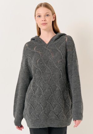 Haut à capuche tricoté gris avec un motif de vagues texturé, manches longues et une coupe décontractée avec une capuche spacieuse. Matière en mélange de laine douce.