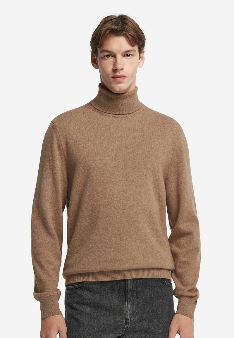 Brun polotröja i mjukt stickat material. Har långa ärmar och ribbade ärmslut och fåll, med en slät textur.