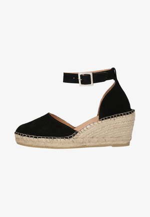 Black suede espadrille wedge with ankle strap, round toe, and woven jute platform. Features a silver buckle and rope detailing.