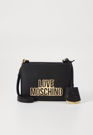 Zwarte leren crossbodytas met gouden "LOVE MOSCHINO" tekst aan de voorkant en bijpassend label hangend aan de riem tegen een witte achtergrond.