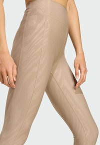Beige Leggings mit hoher Taille und einem dezenten Tiermuster, ausgestattet mit flachen Nähten und einer glatten Textur für Komfort und Flexibilität.