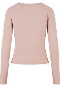 Long-sleeve top in soft pink fabric, featuring a round neckline and a fitted shape with smooth texture and minimal stitching detail.