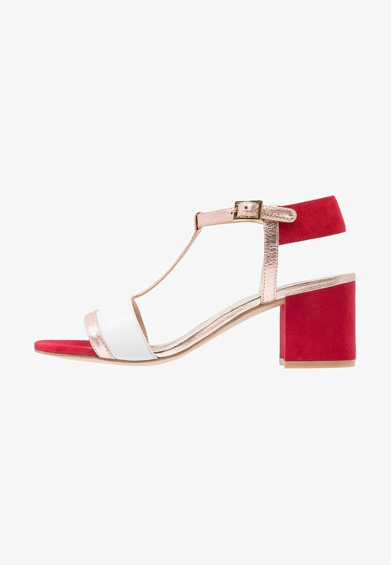 Sandale femme à bout ouvert avec bride avant blanche, bride en T métal rose doré et boucle à la cheville, talon bloc rouge et bride arrière.