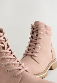 Botas rosas con cordones, con un exterior de cuero suave, puño de tobillo acanalado y cordones texturizados. Incluye ojales plateados y una suela en contraste.