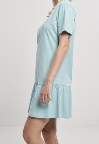 Vaaleansininen, lyhythihainen mekko, jossa on kerätty ja levenevä helma. Valmistettu pehmeästä kankaasta, jossa on yksinkertainen, rento istuvuus.