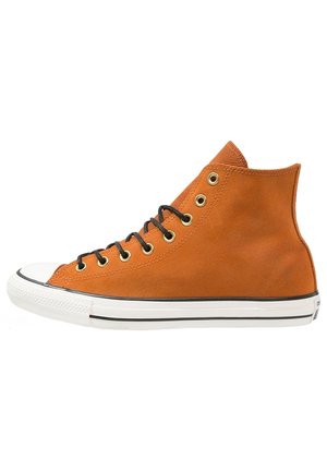 Oranger High-Top-Sneaker mit schwarzen Schnürsenkeln, goldenen Ösen, weißer Gummisohle und schwarzem Streifen entlang der Sohlenkante, Seitenansicht auf weißem Hintergrund.