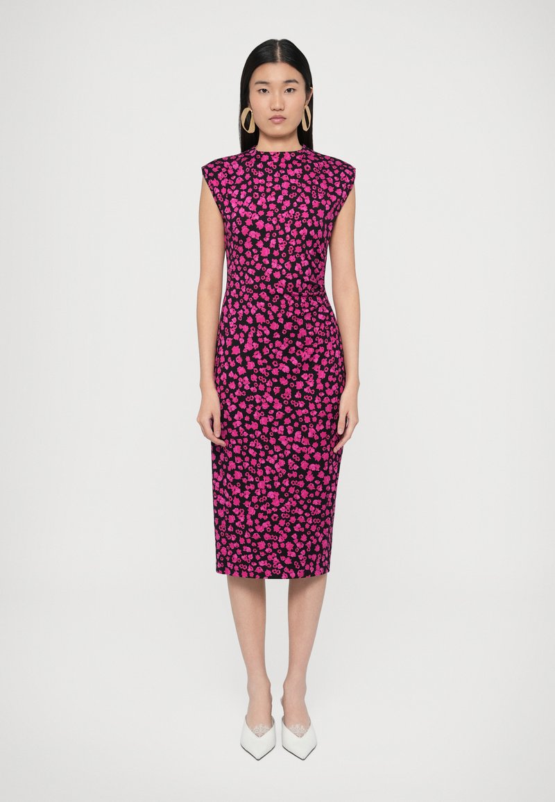 Testhez simuló ruha magas nyakkivágással, rugalmas anyagból, fekete alapon rózsaszín virágmintákkal. Fehér hegyesorrú magassarkú.