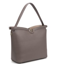 Sac à main en cuir gris avec une forme structurée, doté d'un haut arrondi, d'une seule sangle et d'un détail accent circulaire à l'avant.