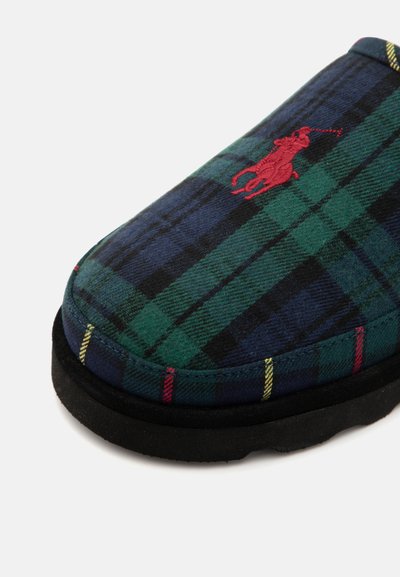 Geruite slipper met groen, marineblauw en rood kleuraccenten, voorzien van een rood geborduurd logo. Zacht bovenwerk van textiel en een zwarte rubberen zool. Rond gevormd.