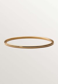 Brazalete de bangle de metal dorado con un acabado liso y pulido. Tiene una forma circular continua, con un perfil delgado y sin adornos.
