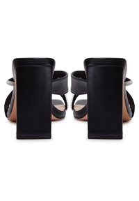 Sandales à talons noirs avec un talon carré épais, double brides et accents décoratifs en strass sur la partie supérieure. Matière en cuir texturé.