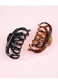 Due grandi clip per capelli: una nera lucida e l'altra decorata con tonalità marroni e ambra. Design curvo con molteplici artigli di presa.