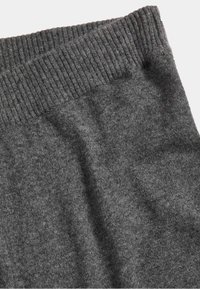 Tessuto a maglia grigio con vita a coste, che mostra una morbida texture e una superficie liscia, adatto per un abbigliamento confortevole.