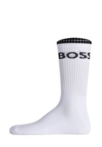 White cotton sock with a ribbed black cuff and black "BOSS" logo. Smooth texture, knee-length design, and reinforced toe area.